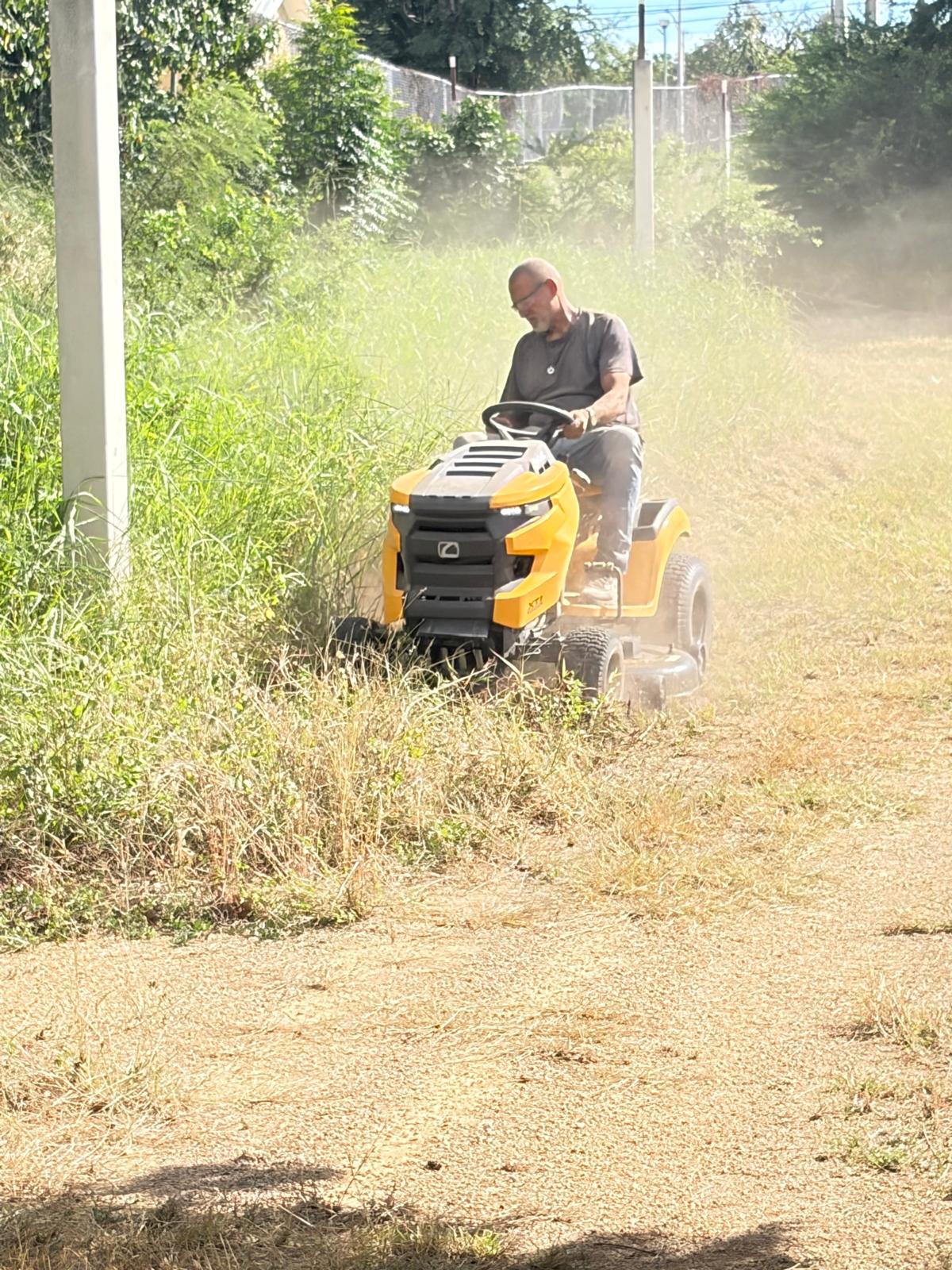 Persona cortando vegetación con equipo de mantenimiento en Lineales de Ponce